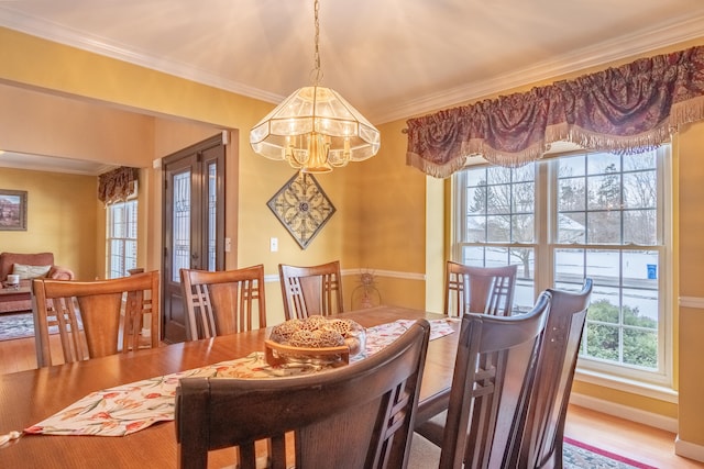 dining area featuring wood-type flooring, a notable chandelier, and crown molding