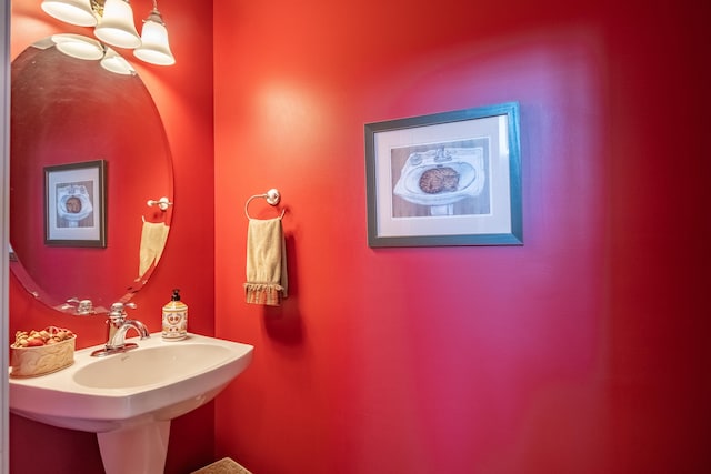 bathroom with sink and a notable chandelier