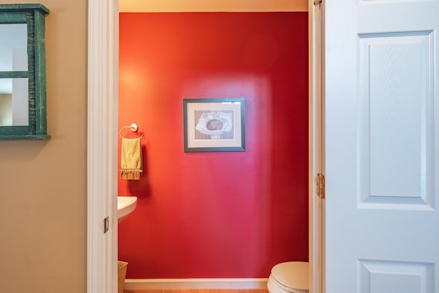 bathroom featuring toilet and wood-type flooring