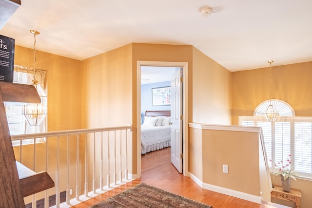 hallway featuring hardwood / wood-style floors and a chandelier