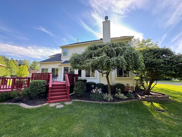 rear view of house with a lawn and a wooden deck