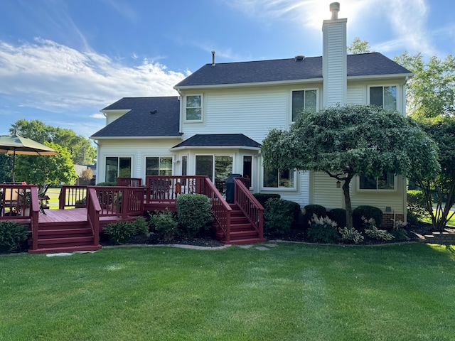 rear view of house featuring a deck and a lawn