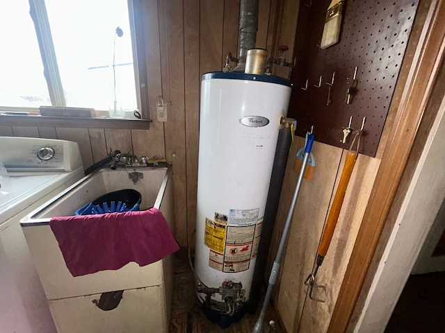 utilities featuring water heater, washer / dryer, and sink