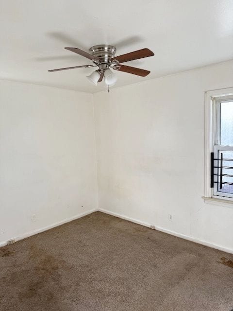 carpeted spare room with ceiling fan