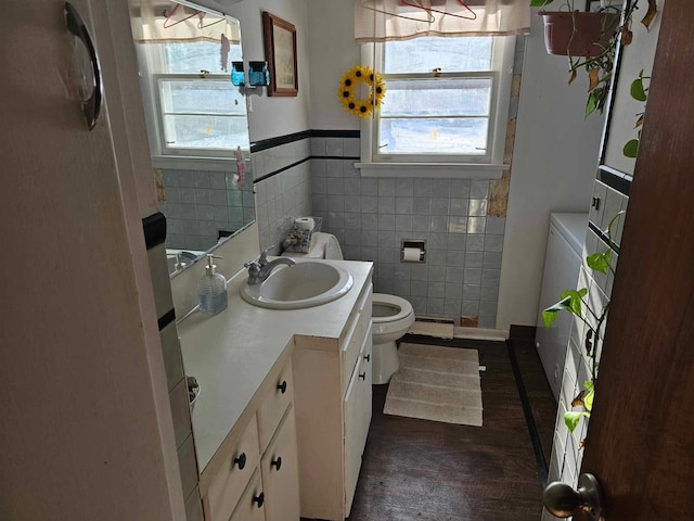 3593 Southern Dr, Hart, MI 49420 - bathroom with toilet, tile walls, a baseboard heating unit, and vanity