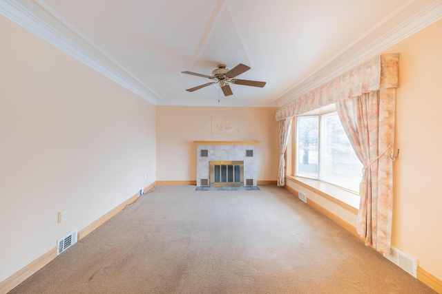 unfurnished living room featuring ceiling fan, a tiled fireplace, light carpet, and ornamental molding