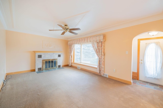 unfurnished living room with ceiling fan, light carpet, a tile fireplace, and ornamental molding