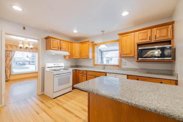 kitchen featuring light stone countertops, white appliances, sink, a chandelier, and light hardwood / wood-style flooring