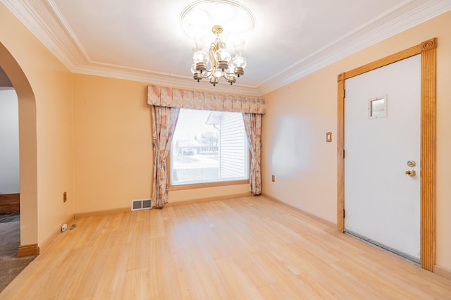 unfurnished room featuring a notable chandelier, ornamental molding, and hardwood / wood-style floors