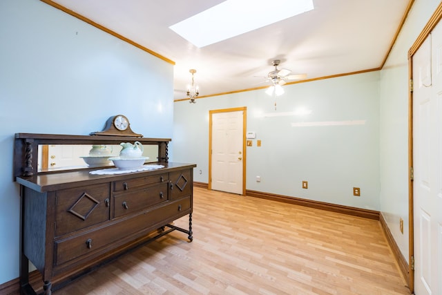 bedroom with crown molding, light hardwood / wood-style flooring, a skylight, and an inviting chandelier