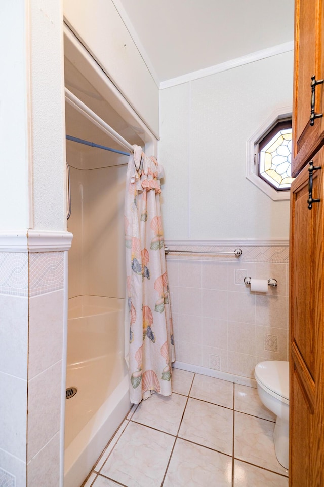 bathroom with toilet, tile walls, tile patterned floors, a shower with curtain, and crown molding