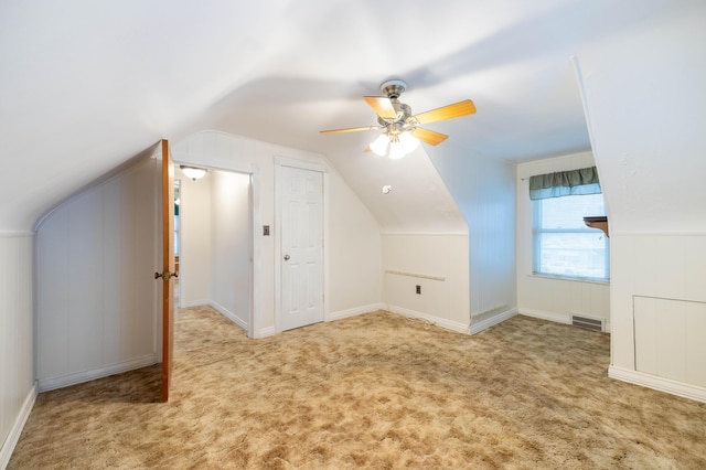 additional living space with light carpet, ceiling fan, and vaulted ceiling