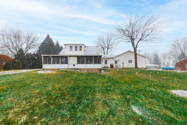 rear view of house with a sunroom and a lawn