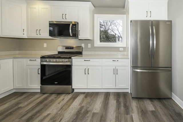 kitchen with dark hardwood / wood-style floors, stainless steel appliances, and white cabinetry