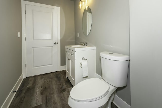 bathroom featuring wood-type flooring, toilet, and vanity