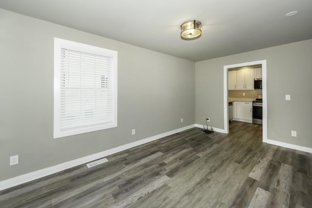 spare room with dark hardwood / wood-style flooring