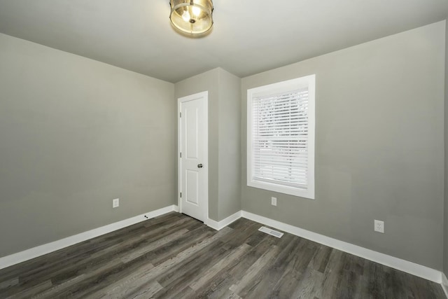 unfurnished room with dark hardwood / wood-style flooring