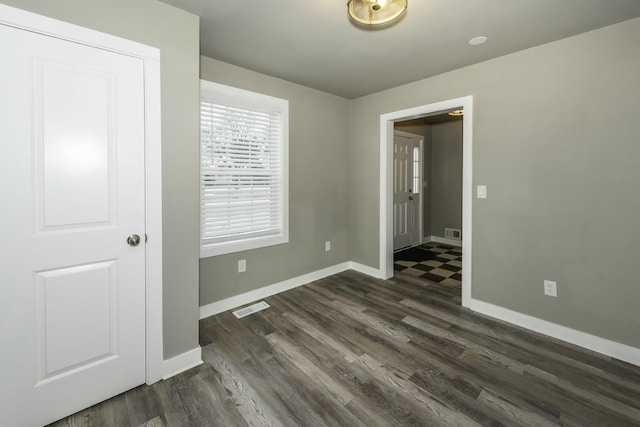 empty room with dark hardwood / wood-style flooring