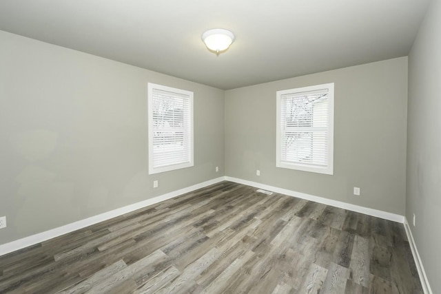 unfurnished room featuring hardwood / wood-style floors and a healthy amount of sunlight