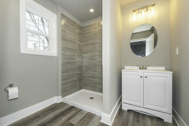 bathroom featuring hardwood / wood-style floors, vanity, and a tile shower