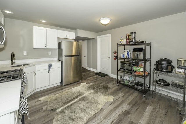 kitchen featuring sink, white cabinetry, dark hardwood / wood-style flooring, and stainless steel appliances