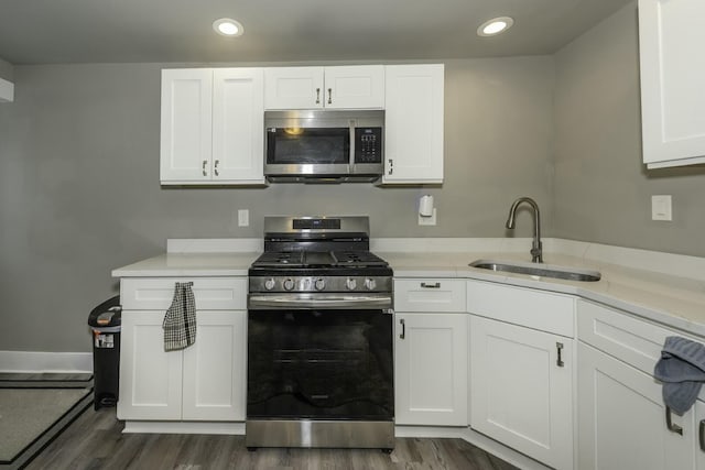 kitchen featuring sink, white cabinets, appliances with stainless steel finishes, and dark hardwood / wood-style flooring