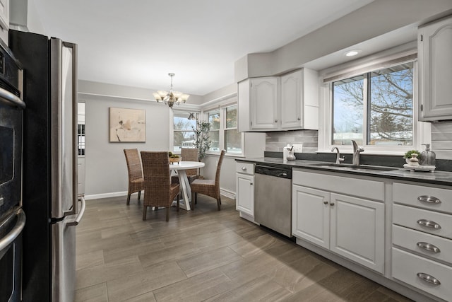 kitchen featuring white cabinets, decorative backsplash, appliances with stainless steel finishes, and sink