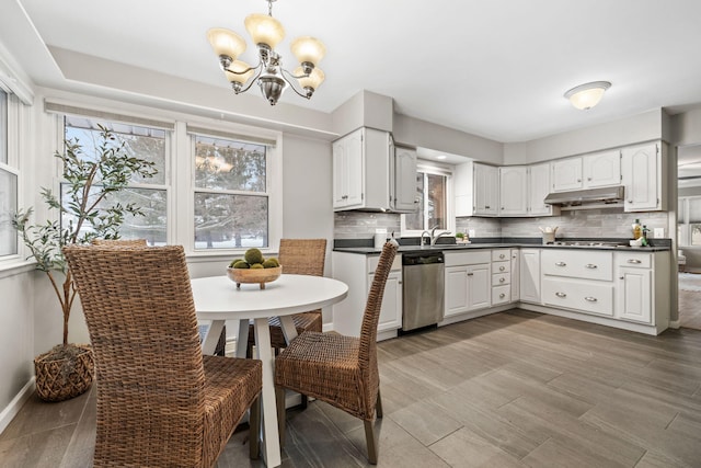 kitchen featuring white cabinetry, appliances with stainless steel finishes, a chandelier, and tasteful backsplash