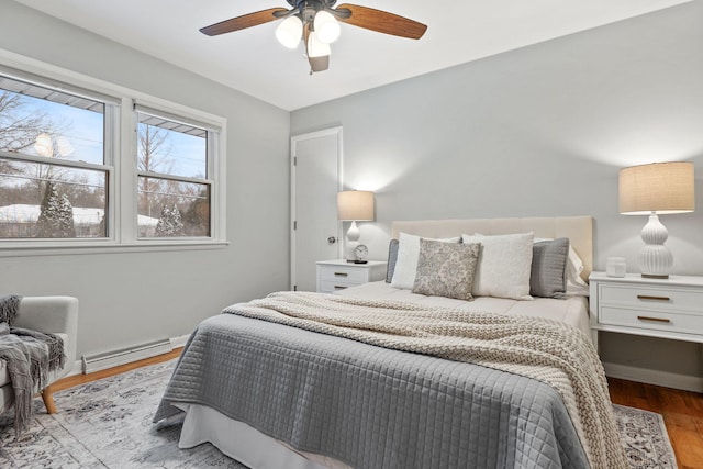 bedroom featuring a baseboard heating unit, ceiling fan, and light wood-type flooring