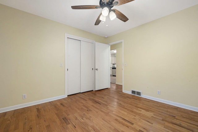 unfurnished bedroom with ceiling fan, light wood-type flooring, and a closet