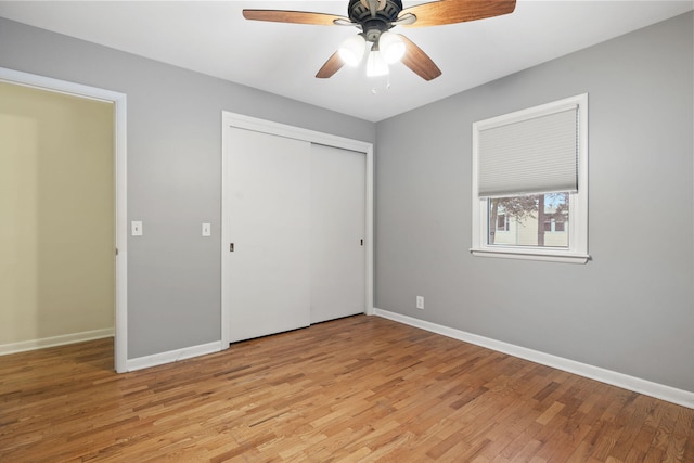 unfurnished bedroom with ceiling fan, light wood-type flooring, and a closet