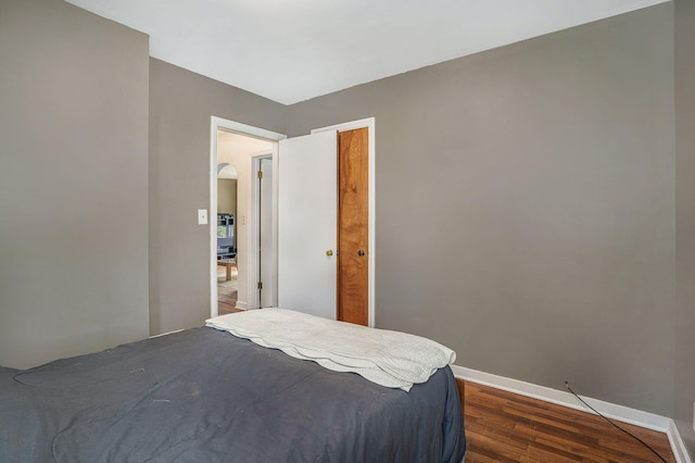 bedroom with dark hardwood / wood-style floors