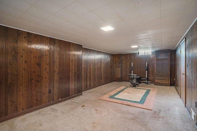 basement with light colored carpet and wood walls