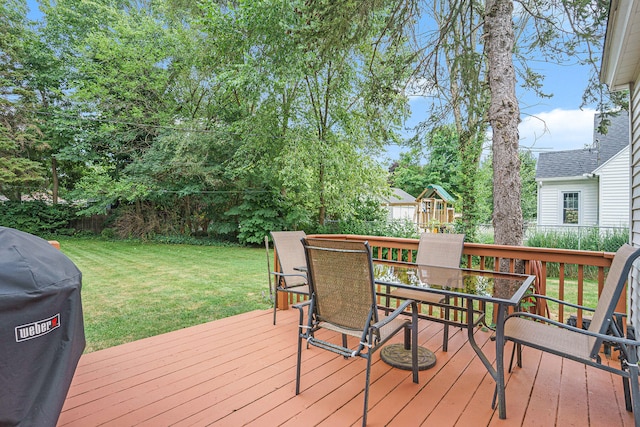 wooden terrace with grilling area, a playground, and a lawn