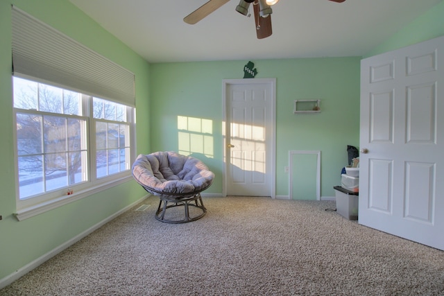 living area with ceiling fan and carpet