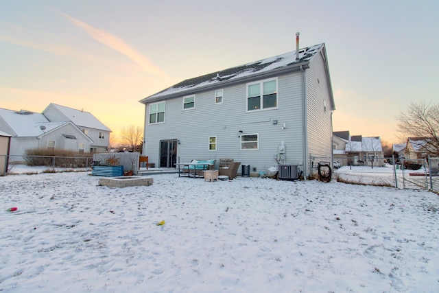 snow covered house with central air condition unit