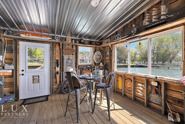 sunroom featuring lofted ceiling and a water view