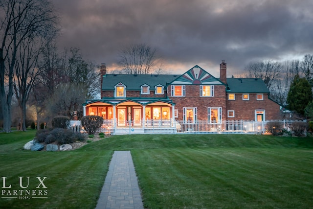 back house at dusk featuring a yard