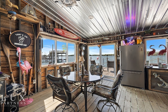 dining space featuring hardwood / wood-style flooring, a water view, and vaulted ceiling