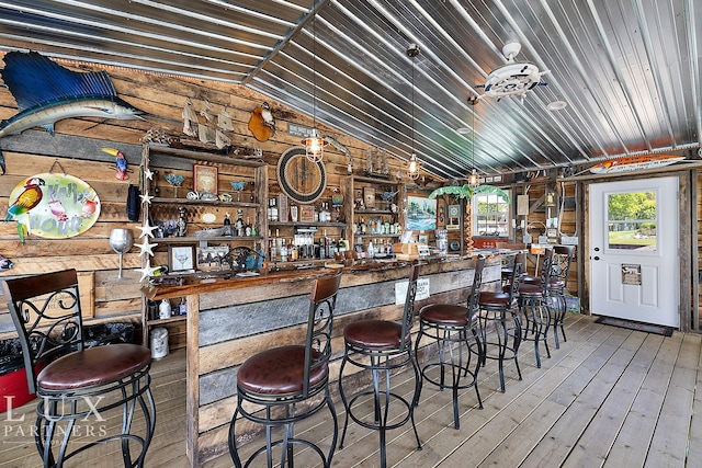 bar with wood walls, hardwood / wood-style floors, lofted ceiling, and wood ceiling