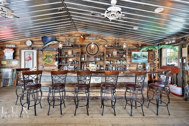 bar featuring wood-type flooring and vaulted ceiling