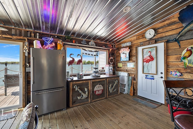 kitchen with wood-type flooring, vaulted ceiling, a water view, and high end fridge