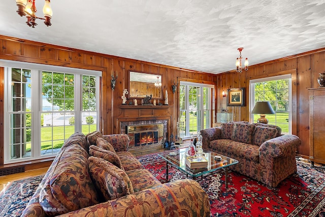 living room with a fireplace, a textured ceiling, and an inviting chandelier