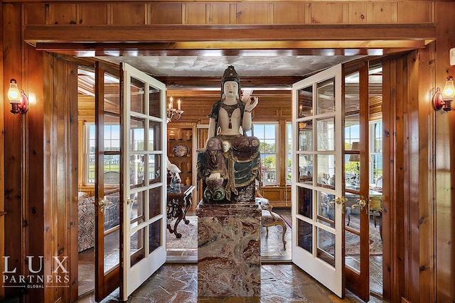 entryway with wooden walls and french doors