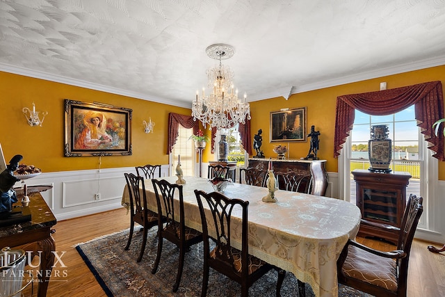 dining room featuring crown molding, plenty of natural light, a notable chandelier, and light hardwood / wood-style floors