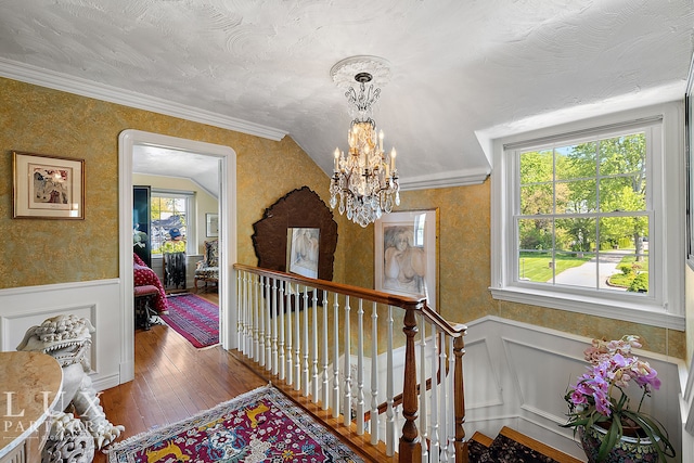 interior space with lofted ceiling, hardwood / wood-style floors, a notable chandelier, and ornamental molding