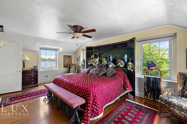 bedroom featuring lofted ceiling, multiple windows, a water view, and ceiling fan