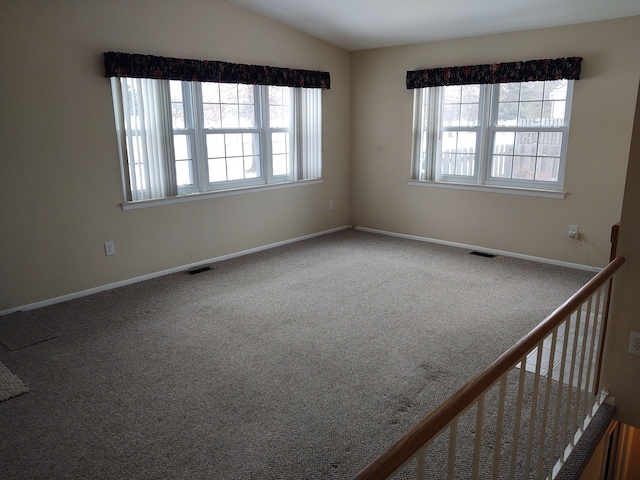 spare room featuring carpet floors and lofted ceiling