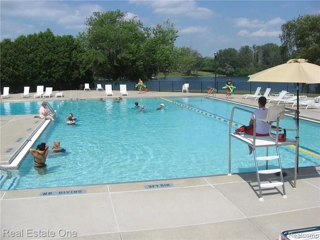 view of pool with a water view and a patio area