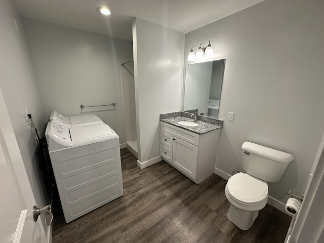 bathroom featuring toilet, wood-type flooring, washer / clothes dryer, and vanity